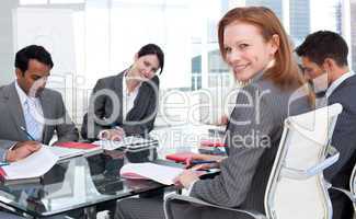 Smiling businesswoman in a meeting with her team