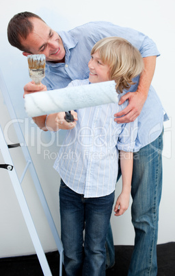 Happy father and his son painting a wall