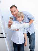 Smiling father and his son holding paintbrush
