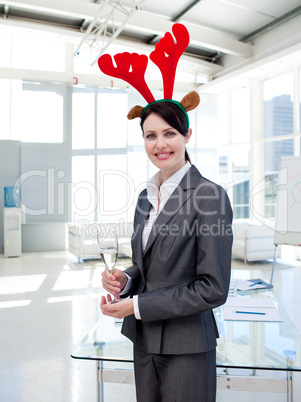 Smiling businesswoman with a novelty Christmas hat drinking Cham