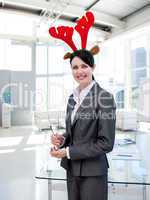 Smiling businesswoman with a novelty Christmas hat drinking Cham