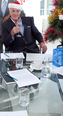 Businessman with a novelty Christmas hat toasting with Champagne