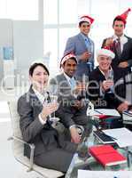 Manager and his team with novelty Christmas hat toasting at a pa