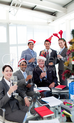 Business people with novelty Christmas hat toasting at a party