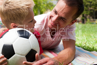 Close-up of an attentive father and his son holding a soccer bal