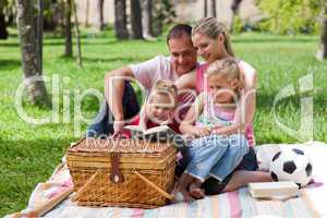 Happy family reading in a park