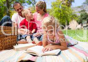 Serious little girl reading while having a picnic