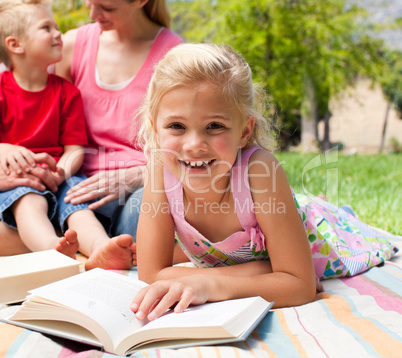 Close-up of a little girl reading at a picnic