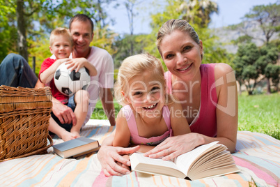 Mother and her daughter reading lying on a picnic tablecloth