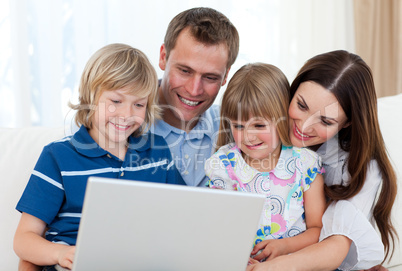 Smiling family using a laptop