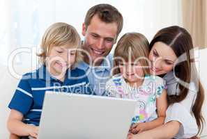 Smiling family using a laptop