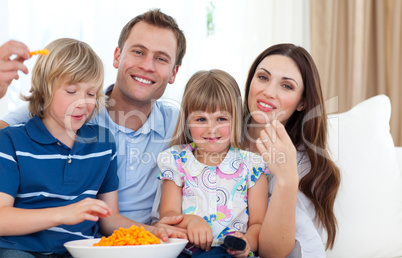 Happy family eating crisps