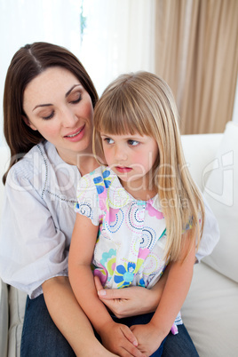 Cute blond girl sitting on her mother's lap