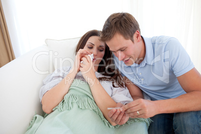 Attentive man taking his wife's temperature