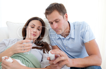 Young man looking after his wife with the flu