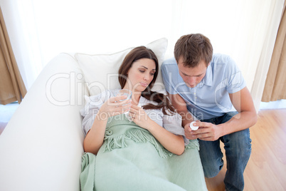 Man giving pills to his sick wife