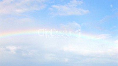 HD rainbow in blue sky with clouds