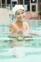 young blonde in a pool with a bathing cap