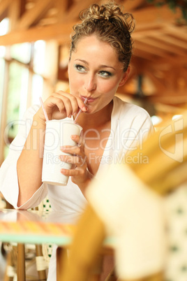 young blonde drinks out of a mug