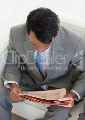 Ethnic businessman reading a newspaper