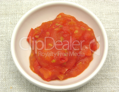 Tomatendip in kleiner Porzellanschale vor beigem Hintergrund