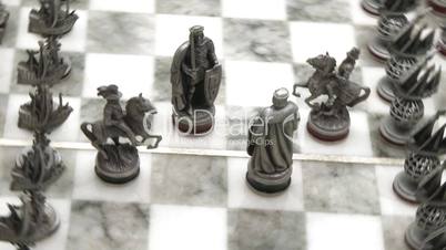 Silver chess pieces on board rotate