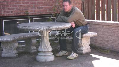 Man sitting and comtemplating at outdoor bench