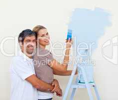 Smiling lovers painting a room