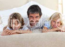 father and his children lying on a bed