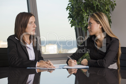 Zwei Geschäftsfrauen schauen sich misstrauisch an