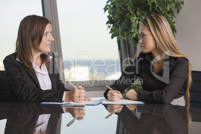Zwei Geschäftsfrauen schauen sich an