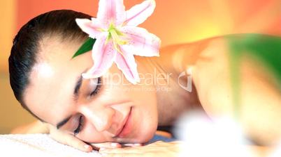Close up of young woman in a spa with flower