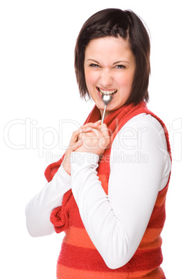 Junge Frau mit einem Löffel im Mund