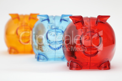 Three colorful piggy banks in a row