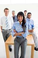 Assertive manager with folded arms in front of her team