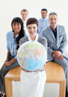 Smiling business team holding a terrestrial globe