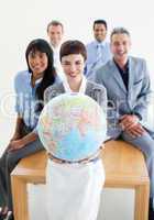 Smiling business team holding a terrestrial globe