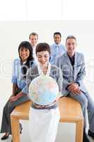 Positive international business people holding a terrestrial glo