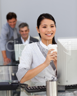 Young Businesswoman drinking a coffee at her desk