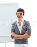 Confident businesswoman with folded arms in front of a board