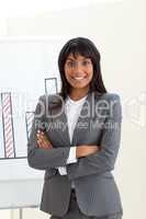 Ethnic businesswoman with folded arms in front of a board