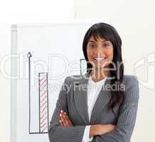 Afro-american businesswoman with folded arms in front of a board