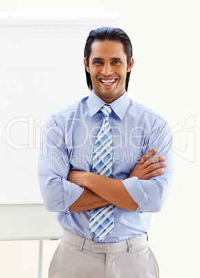 Cheerful ethnic businessman in front of a board