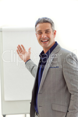 Cheerful mature businessman pointing at a board