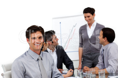 Smiling male executive at a presentation with his team