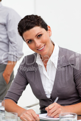 Assertive young businesswoman taking notes