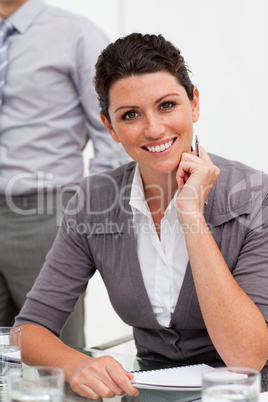 Smiling confident businesswoman taking notes