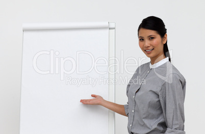 Self-assured asian female executive pointing at a board