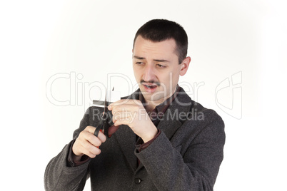 Frustrated man cutting a credit card