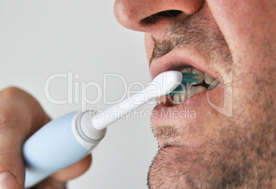 Man brushing his teeth with electric toothbrush